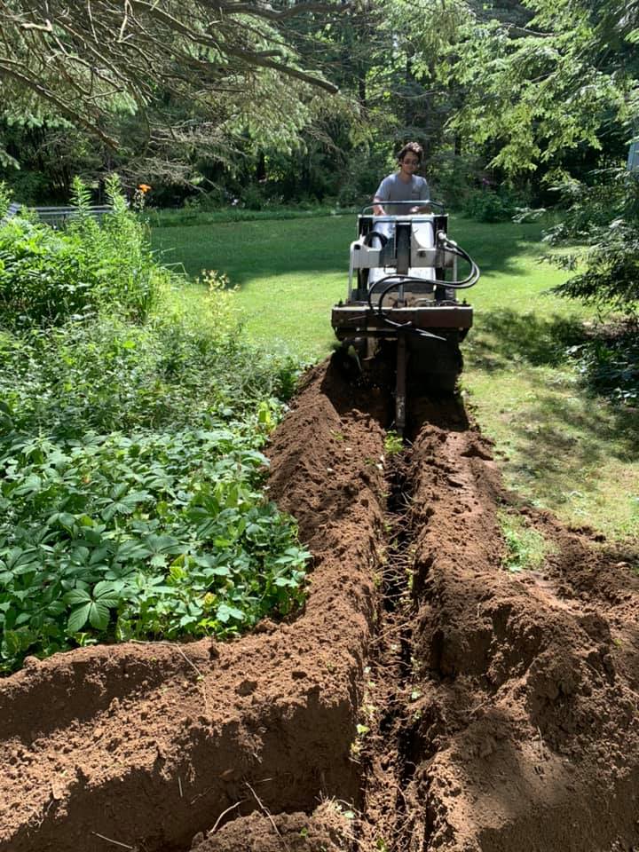 An electrician riding a lawn mower on a dirt path in Erie, PA.
