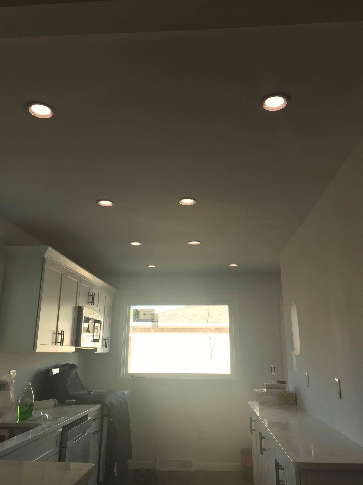 A kitchen with a white ceiling and light fixtures, serviced by electrical contractors in Erie PA.