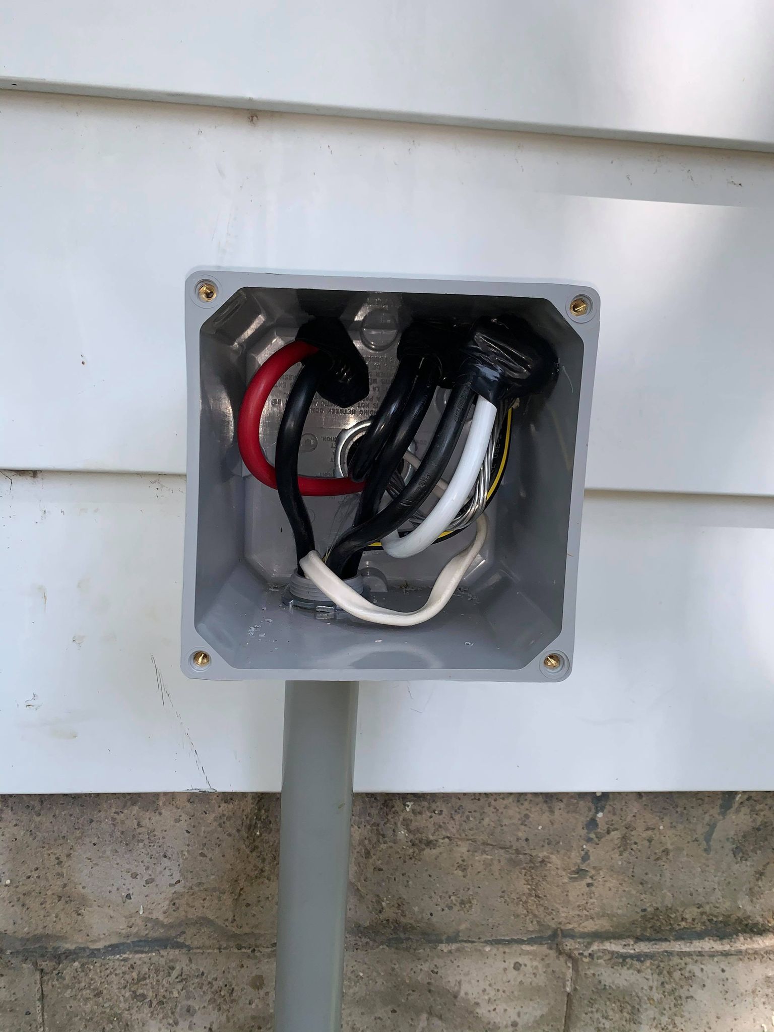 A box with wires attached to it on the side of a house, installed by a residential electrician in Erie, PA.