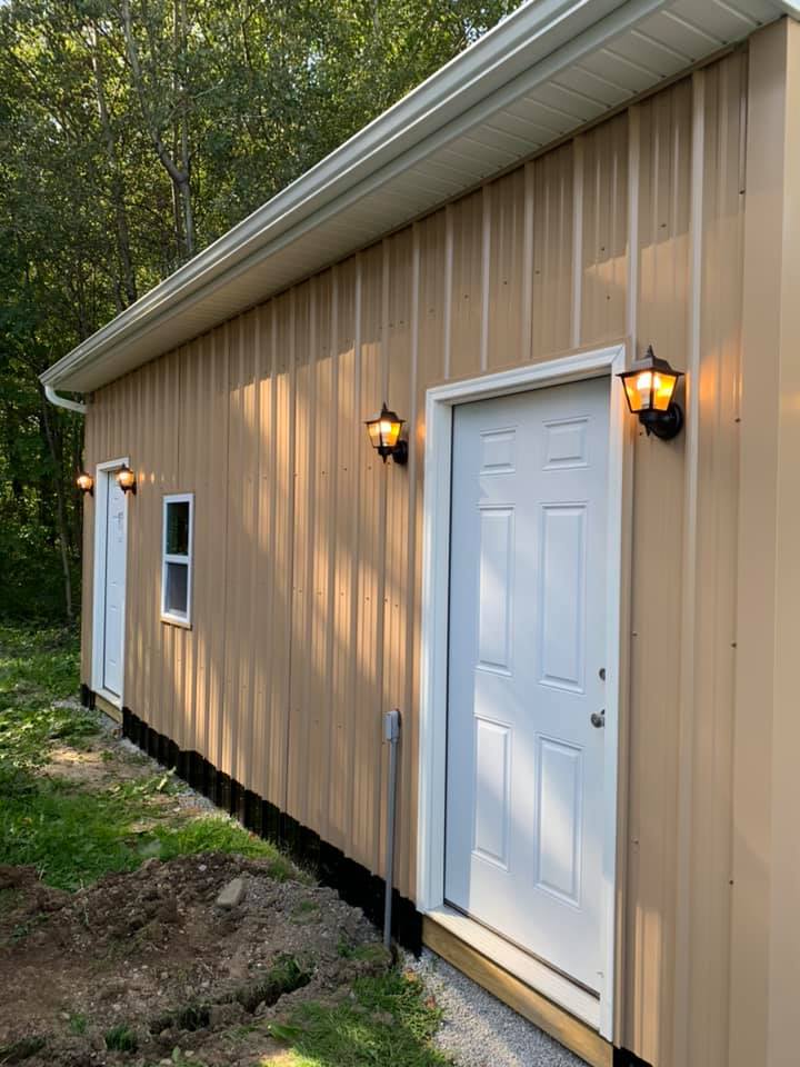 A tan metal building with a door and two windows, suitable for residential electrician professionals in Erie, PA.